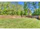 Spacious fenced backyard with green grass, garden beds, and a firepit area perfect for outdoor entertaining at 76 Bergeson Ct, Fuquay Varina, NC 27526