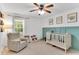 Cozy bedroom featuring a ceiling fan, a sitting chair, and a stylish baby crib at 76 Bergeson Ct, Fuquay Varina, NC 27526