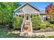Inviting front porch with brick steps, white railings, flowering plants, and a well-manicured lawn at 76 Bergeson Ct, Fuquay Varina, NC 27526
