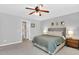 Bright main bedroom featuring a ceiling fan, carpet flooring, and ensuite bathroom access at 76 Bergeson Ct, Fuquay Varina, NC 27526