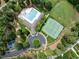 Aerial shot showcasing the community pool, tennis courts, and recreational facilities nestled among trees at 77 Ruffed Grouse, Chapel Hill, NC 27517