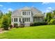 Large backyard with lush green lawn and a home featuring a screened in porch and bay windows at 77 Ruffed Grouse, Chapel Hill, NC 27517