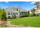 Spacious backyard with lush green grass, flowing river rock, and a covered porch providing a serene retreat at 77 Ruffed Grouse, Chapel Hill, NC 27517
