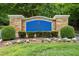 Elegant community sign with stone accents and landscaping, welcoming residents and visitors at 77 Ruffed Grouse, Chapel Hill, NC 27517