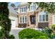 Beautiful home exterior showcasing stone accents, arched entry and manicured landscaping at 77 Ruffed Grouse, Chapel Hill, NC 27517