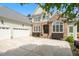 Elegant home with stone and siding, a three-car garage, and a manicured lawn enhances the property's curb appeal at 77 Ruffed Grouse, Chapel Hill, NC 27517