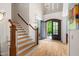 Bright foyer with hardwood floors, staircase, chandelier, and grand doorway enhancing the entrance at 77 Ruffed Grouse, Chapel Hill, NC 27517