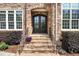 Close up of front door showing stone archway, steps, iron railing, and manicured landscaping at 77 Ruffed Grouse, Chapel Hill, NC 27517