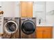 Functional laundry area featuring a sink, wooden cabinetry, and modern appliances at 77 Ruffed Grouse, Chapel Hill, NC 27517