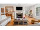 Cozy living room featuring a stone fireplace, hardwood floors, and neutral decor at 77 Ruffed Grouse, Chapel Hill, NC 27517