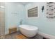 Contemporary bathroom with standalone tub, accent window, and stylish fixtures at 7901 Farnham Ct, Raleigh, NC 27615