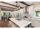Modern kitchen with an island, sleek white cabinets, stainless steel appliances, and hardwood floors at 7901 Farnham Ct, Raleigh, NC 27615