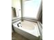 Bathroom with a soaking tub, tile backsplash, and a window at 808 Buckner Ct, Fuquay Varina, NC 27526