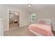 A bedroom with carpeted floors, a pink bed and a small nook with a glider at 808 Buckner Ct, Fuquay Varina, NC 27526