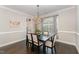 Inviting dining room featuring elegant chandelier, dark wood table with seating for six, and natural lighting at 808 Buckner Ct, Fuquay Varina, NC 27526