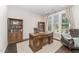 Comfortable home office with classic wooden desk, built-in bookshelves, and a plush leather chair, ideal for remote work at 808 Buckner Ct, Fuquay Varina, NC 27526