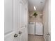 A view of the laundry room with white washer and dryer, shelving, and tiled floor at 808 Buckner Ct, Fuquay Varina, NC 27526