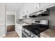 Well-lit kitchen featuring a stainless steel range and ample cabinet space, open to an adjoining room at 809 Leon St, Durham, NC 27704
