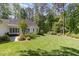 Expansive backyard featuring lush lawn, mature trees, and a charming patio, perfect for outdoor enjoyment at 8304 Epping Forest Way, Wake Forest, NC 27587