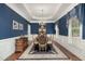 Elegant dining room featuring blue walls, a chandelier, and a round table with seating for six at 8304 Epping Forest Way, Wake Forest, NC 27587