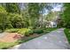 Long driveway leading to a well-maintained home surrounded by lush landscaping and mature trees at 8304 Epping Forest Way, Wake Forest, NC 27587