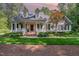 Charming home featuring a welcoming front porch, red door, and lush, manicured landscaping at 8304 Epping Forest Way, Wake Forest, NC 27587