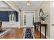 Elegant foyer with hardwood floors, decorative rug, console table with mirror, and white front door at 8304 Epping Forest Way, Wake Forest, NC 27587