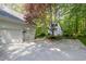 Spacious driveway leading to a two car garage and a charming shed in a serene wooded setting at 8304 Epping Forest Way, Wake Forest, NC 27587