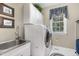 Laundry room with stainless steel sink and modern washer and dryer at 8304 Epping Forest Way, Wake Forest, NC 27587