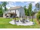 Backyard with a fire pit area, back of house, and a manicured lawn at 8616 Deep Elm Dr, Wake Forest, NC 27587