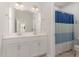 Clean bathroom with double sinks, a large mirror, and a blue shower curtain at 8616 Deep Elm Dr, Wake Forest, NC 27587