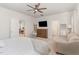 Bright bedroom features a ceiling fan, a dresser with a TV, and a comfortable sitting area at 8616 Deep Elm Dr, Wake Forest, NC 27587