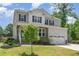 Two-story home with gray siding, black shutters, stone accents, and a well-manicured front lawn at 8616 Deep Elm Dr, Wake Forest, NC 27587