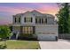 Charming two-story home with a well-manicured lawn and a two-car garage under a colorful dusk sky at 8616 Deep Elm Dr, Wake Forest, NC 27587