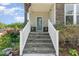 Stone stairs lead to the covered porch with white railing and a beautiful garden at 8616 Deep Elm Dr, Wake Forest, NC 27587