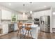 Modern kitchen features white cabinets, stainless steel appliances, tiled backsplash, and a kitchen island at 8616 Deep Elm Dr, Wake Forest, NC 27587