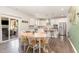 Eat-in kitchen boasts stainless steel appliances, white cabinetry, pendant lighting, and sliding glass door to outdoor patio at 8616 Deep Elm Dr, Wake Forest, NC 27587