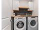 Functional laundry room with stacked appliances, wooden countertop, and custom backsplash at 8616 Deep Elm Dr, Wake Forest, NC 27587