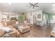 Spacious living room with hardwood floors, open floor plan, a ceiling fan, and access to the kitchen at 8616 Deep Elm Dr, Wake Forest, NC 27587