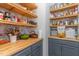 Pantry with butcher block countertops and open shelving with floral wallpaper at 8616 Deep Elm Dr, Wake Forest, NC 27587