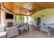 Inviting covered patio with a stone fireplace, comfortable seating, and an outdoor dining area at 8616 Deep Elm Dr, Wake Forest, NC 27587