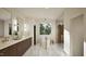 The bathroom showcases a double vanity with gold hardware, soaking tub, and a window view at 909 Oberlin Rd, Raleigh, NC 27605