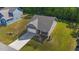 Overhead shot of a gray home featuring brick, attached garage, tidy lawn, and private backyard setting at 94 Shooting Star Ln, Clayton, NC 27520