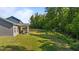 Spacious backyard features a covered patio and a lush lawn that extends to a wooded area at 94 Shooting Star Ln, Clayton, NC 27520