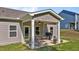 Inviting covered patio in backyard with outdoor seating, grill, ceiling fan, and attractive landscaping at 94 Shooting Star Ln, Clayton, NC 27520