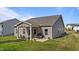Lovely home backyard with covered patio featuring a grill and outdoor furniture on a well-maintained lawn at 94 Shooting Star Ln, Clayton, NC 27520