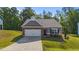 Charming single-story home featuring a brick and siding exterior, attached garage, and well-maintained landscaping at 94 Shooting Star Ln, Clayton, NC 27520