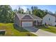 Well-kept one-story home with attached garage, gray siding, brick accents, and verdant lawn at 94 Shooting Star Ln, Clayton, NC 27520