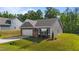 Cozy single-story house with a manicured lawn, attached garage, and complemented by lush, mature trees at 94 Shooting Star Ln, Clayton, NC 27520