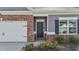 Close-up showcasing the front entry, attached garage, brickwork, and landscaping of a charming home at 94 Shooting Star Ln, Clayton, NC 27520